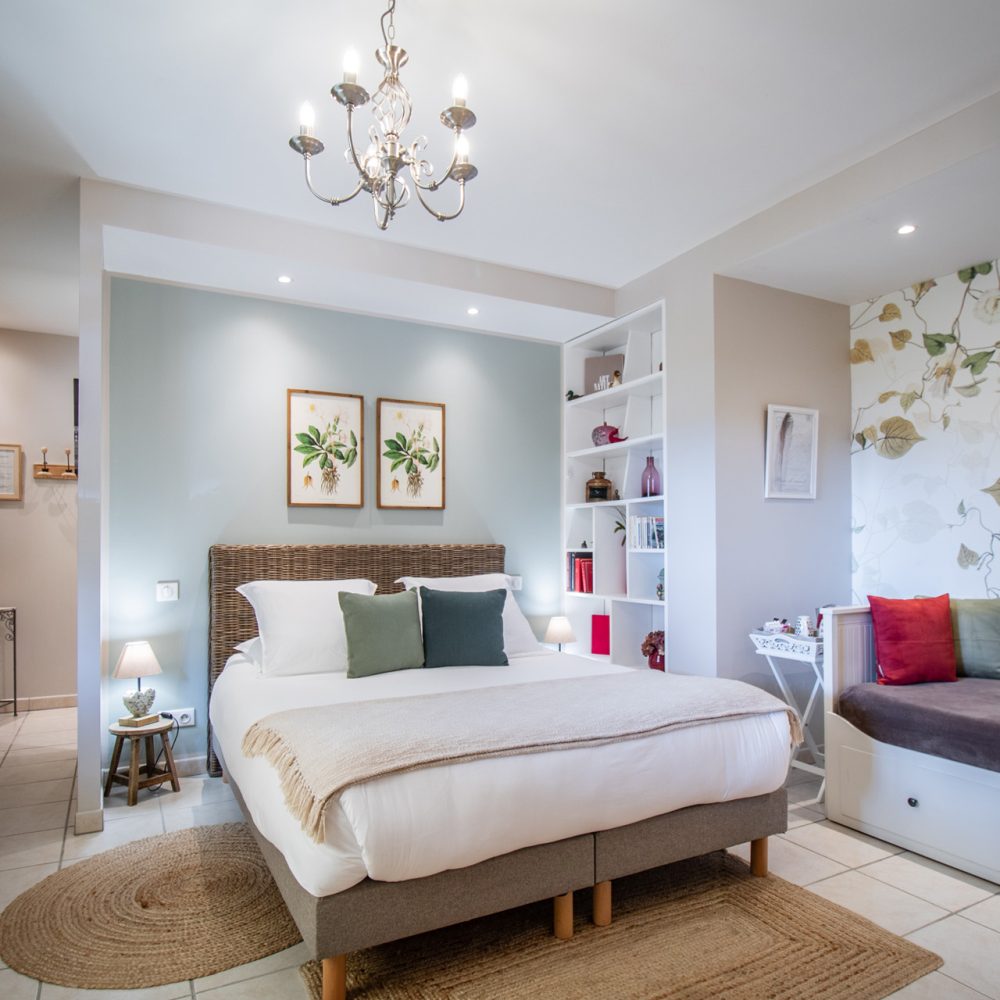 Chambre Bergerac avec lit et coussins rouges, décor romantique