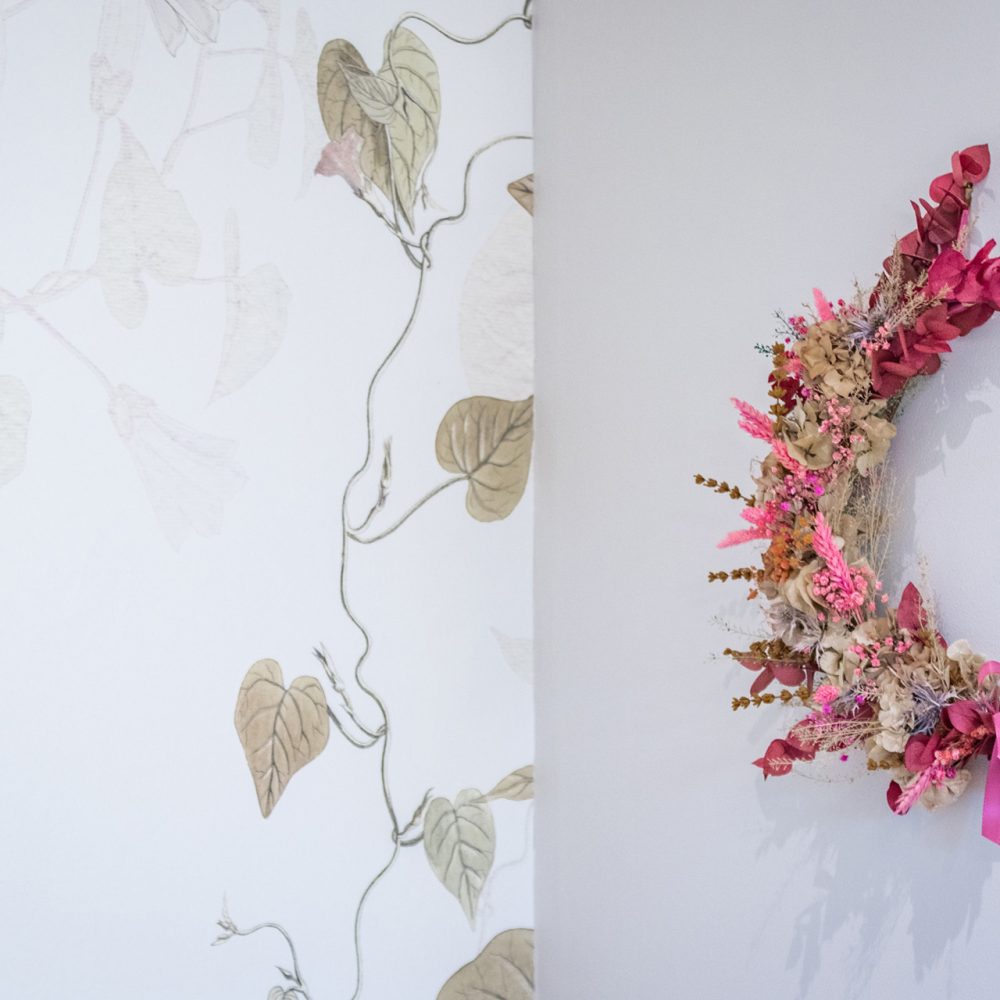 Couronne de fleurs séchées roses sur papier peint doré dans la Chambre Bergerac