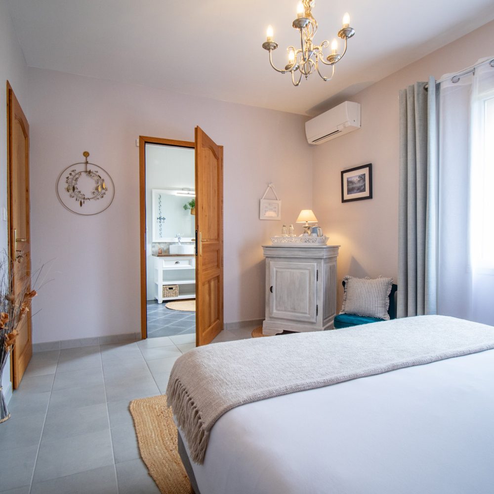 Vue d'ensemble de la Chambre Brantôme avec commode blanche et lustre