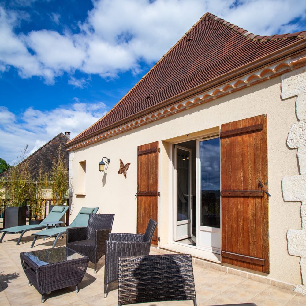 Terrasse extérieure de la Chambre Sarlat et façade en pierre avec vue panoramique