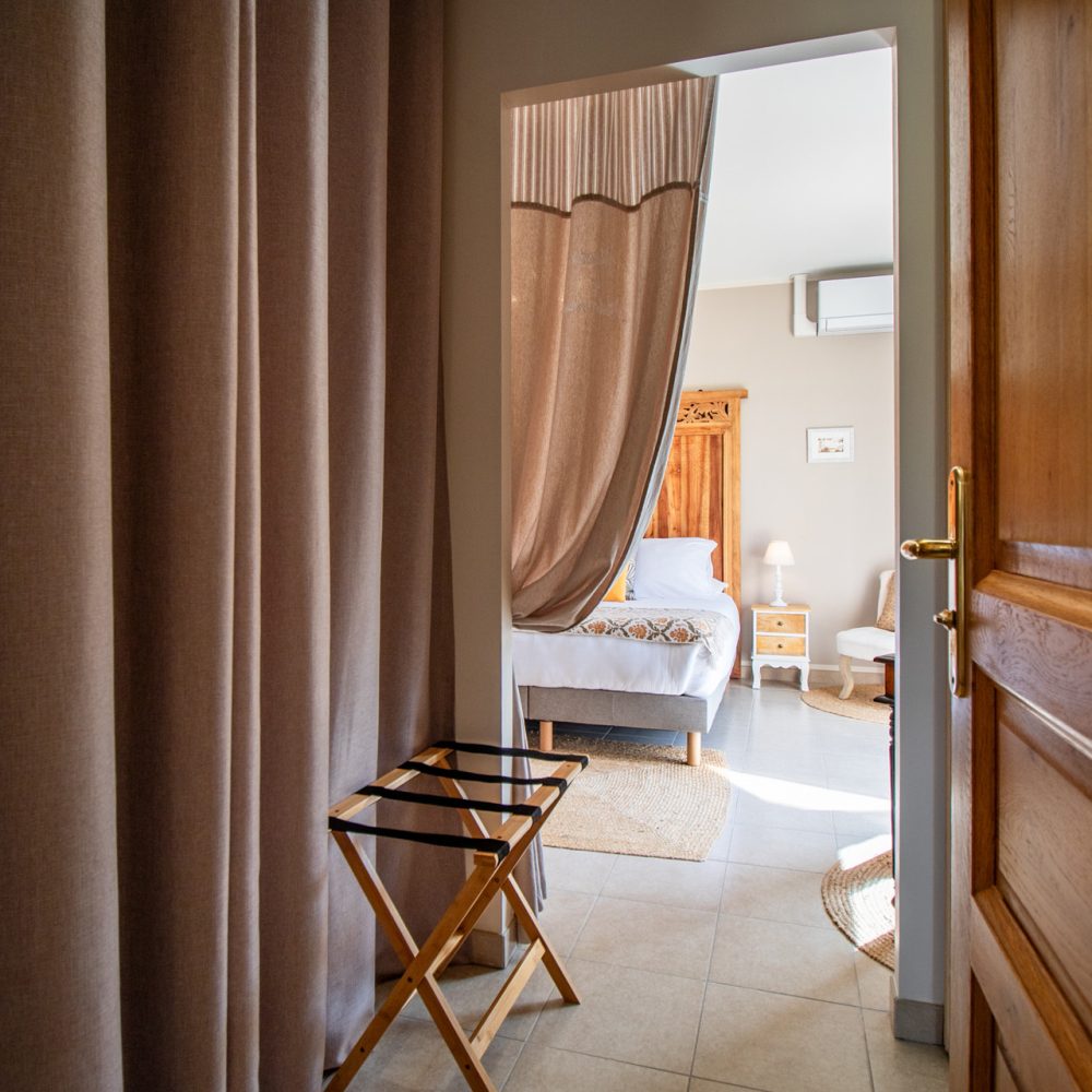 Coin fauteuil et rideaux dans la Chambre Sarlat