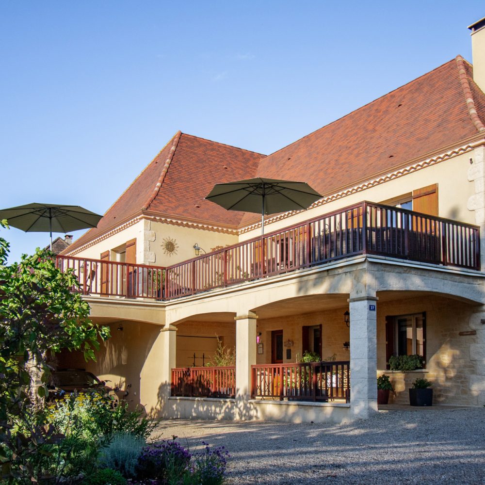 Façade et terrasse de la maison d’hôtes avec parasols, chambres d’hôtes à Sarlat