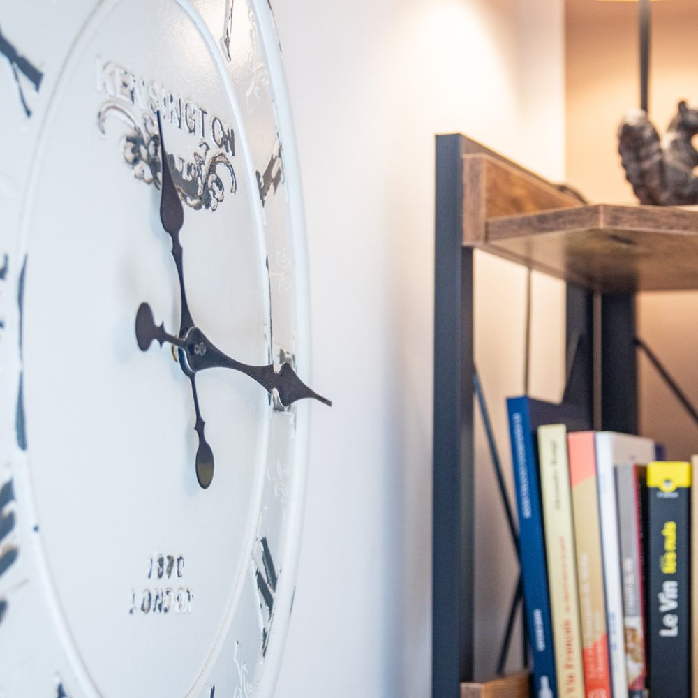 Étagère de livres et horloge dans la salle de petit-déjeuner en Périgord noir
