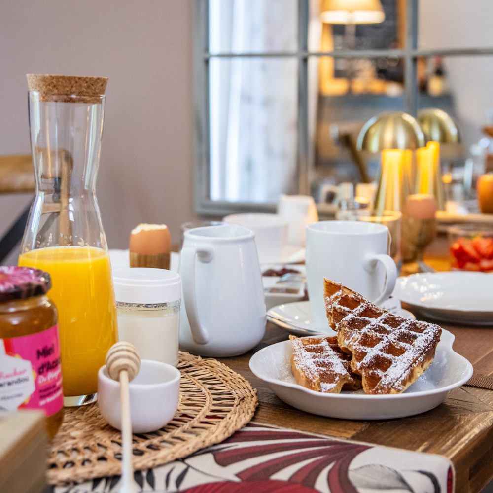 Table de petit-déjeuner avec carafe de jus et confitures maison