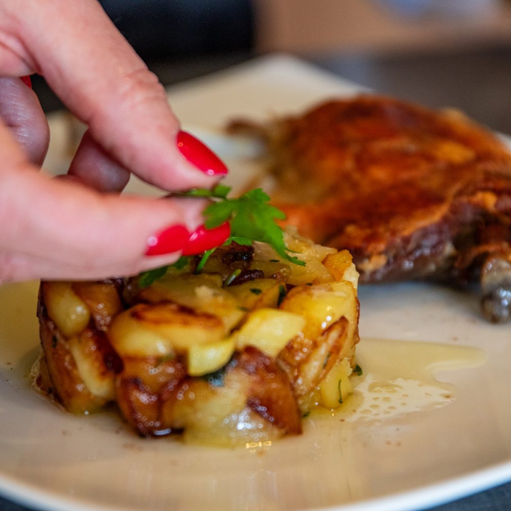 Plat de viande et gratin doré dressés à la table d'hôtes