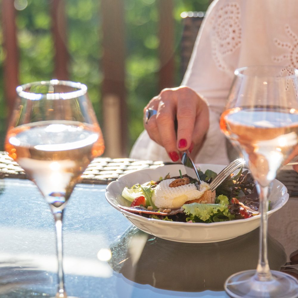 Convives trinquant au rosé à table à la table d'hôtes